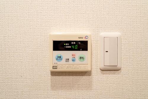 a electronic device with a clock on a wall at Belle Lead 105 in Tokyo