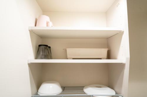 a closet with two toilets and a shelf at Belle Lead 105 in Tokyo