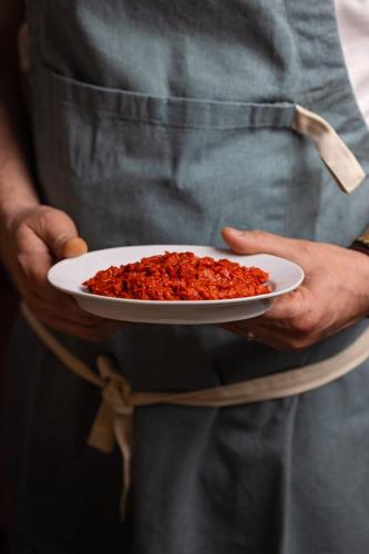 a man holding a plate of food in his hands at Bujtina Jaki in Gjakove