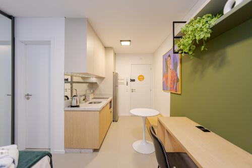 una cucina con lavandino e tavolo in una stanza di Log! Curitiba a Curitiba