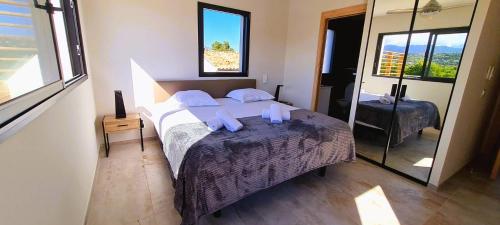 une chambre avec un grand lit et un miroir dans l'établissement Villa Florida, 8 pers, vue montagne, 350 m plage à pieds, à Pinarellu