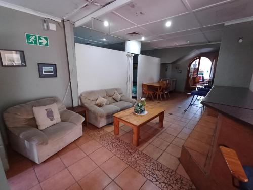a living room with two couches and a table at Oceanic Flashpackers accommodation in East London