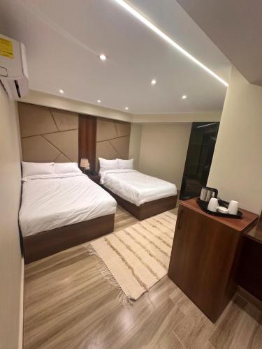 a bedroom with two beds and a dresser in it at Giza Palace Pyramids View in Cairo