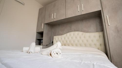 a bedroom with a white bed with towels on it at Free Parking - San Gerardo cosy apartment in Vedano al Lambro