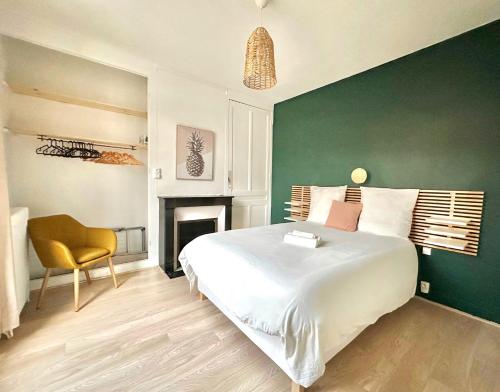 a bedroom with a white bed and a green wall at Maison Familiale Le Havre in Le Havre