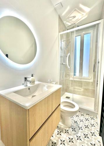 a bathroom with a sink and a toilet and a mirror at Maison Familiale Le Havre in Le Havre