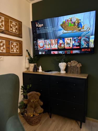 a room with a television and a dresser with a teddy bear at Emerald Chalet in Praid