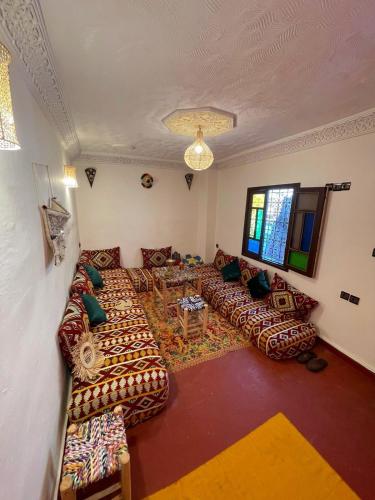 Una gran sala de estar con sofás y una mesa. en Dar Boujloud Fez, en Fez