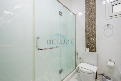 a bathroom with a glass shower with a toilet at Country-side Farm Villa Best for Group Gatherings by Deluxe Holiday Homes in Fujairah