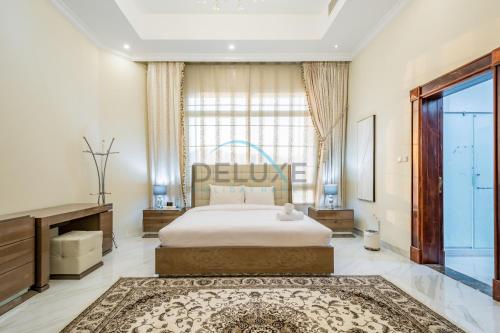 a bedroom with a bed and a large window at Country-side Farm Villa Best for Group Gatherings by Deluxe Holiday Homes in Fujairah