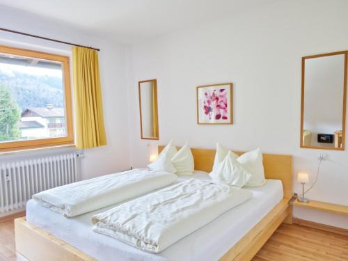 a large white bed in a room with a window at Hotel Garni Landhaus Sonnenstern in Schönau am Königssee