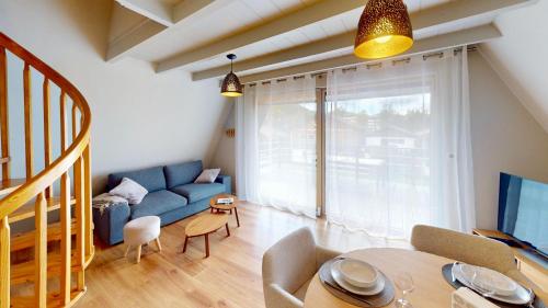 un soggiorno con un divano blu e un tavolo di Chalet l'Escale a Métabief