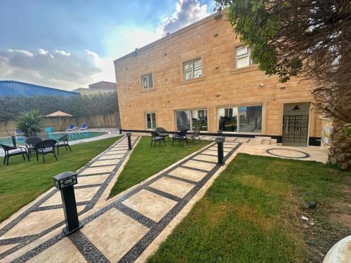 a building with tables and chairs in a yard at Giza Palace Pyramids View in Cairo