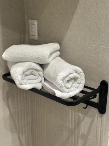 a pile of towels on a towel rack in a bathroom at Giza Palace Pyramids View in Cairo