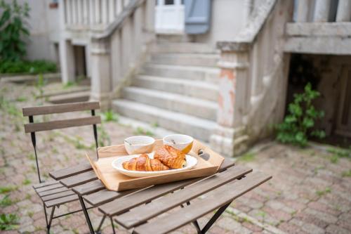 une table en bois avec une assiette de nourriture dessus dans l'établissement Élégance Moderne - Calme Absolu - Proche Lac & Parcs, à Vichy