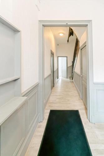 - un couloir avec un tapis vert au sol dans l'établissement Élégance Moderne - Calme Absolu - Proche Lac & Parcs, à Vichy