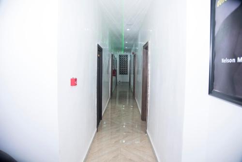 a hallway of a building with white walls and wooden floors at White Angel Hotel Kubwa in Kubwa