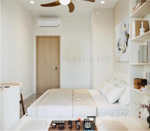 a white bedroom with a bed and a ceiling fan at Suzon-Luxurious Apartment at Lumiere Boulevard VGP in Gò Công