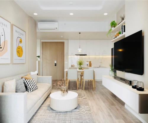 a living room with a white couch and a table at Suzon-Luxurious Apartment at Lumiere Boulevard VGP in Gò Công