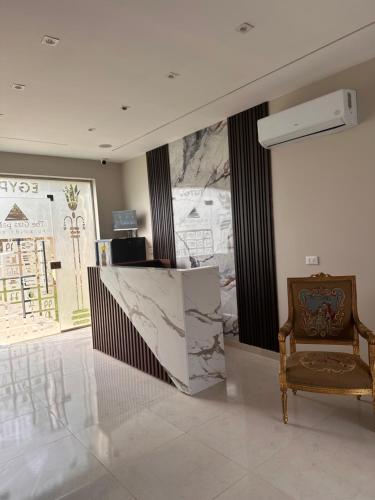 a lobby with a chair and a marble counter at Giza Palace Pyramids View in Cairo