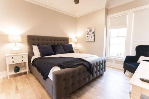 a bedroom with a large bed and a chair at Minutes to Downtown Huge Outdoor Deck HOT TUB in Nashville