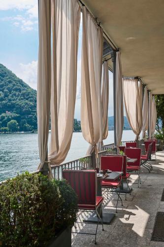a row of tables and chairs next to a body of water at Hotel Villa Flori in Como