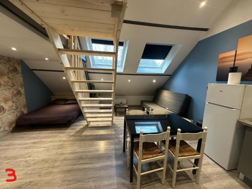 une chambre avec un escalier, une table et un canapé dans l'établissement gites des cigognes, à Dunkerque