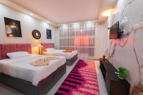 une chambre d'hôtel avec deux lits et une télévision dans l'établissement scandic resort 647, à Hurghada