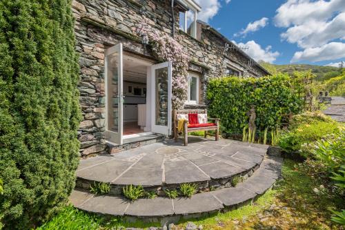 a stone house with a garden and a patio at Dwarf Hall - central Ambleside in Ambleside