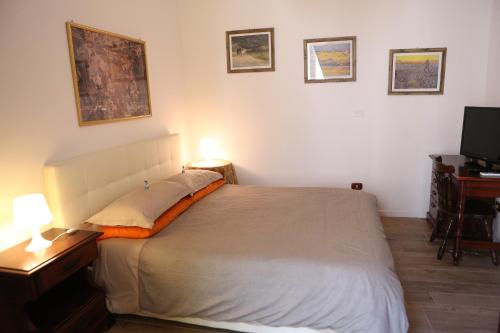 a bedroom with a bed and a desk and a television at Marconi by PizzoApartments in Pizzo