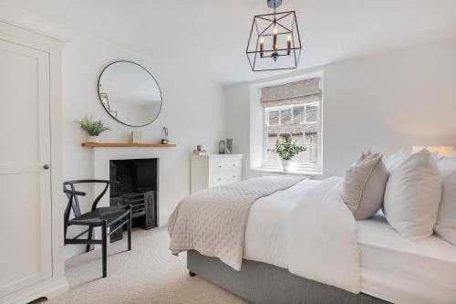 a bedroom with a bed and a chair and a mirror at Weavers Cottage Newly converted luxurious retreat in Kirkby Lonsdale