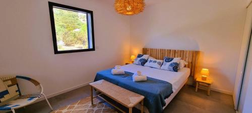 une chambre avec un lit avec des draps bleus et une fenêtre dans l'établissement Villa Alba, 8 pers, piscine chauffée, 5 minutes plage, à Cirendinu