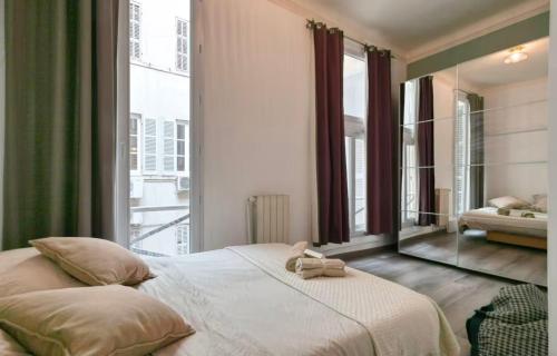 une chambre avec un grand lit et une grande fenêtre dans l'établissement Le Magnifique Grande terrasse, à Marseille