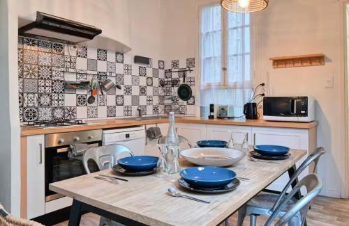 Il dispose d'une cuisine avec une table en bois et des plats bleus. dans l'établissement Le Magnifique Grande terrasse, à Marseille