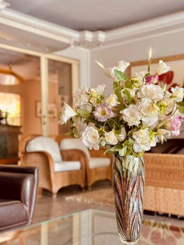 a vase filled with white flowers sitting on a table at Skalla Hotel Nova Odessa in Nova Odessa