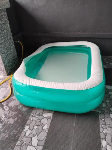 a green and white dog bed sitting on the floor at Homestay Lyn Impian in Tanjung Rambutan