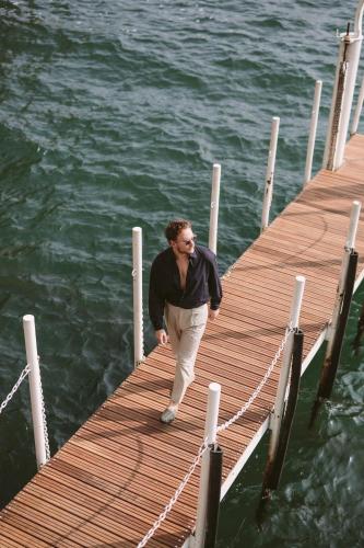 a man walking on a dock in the water at Hotel Villa Flori in Como