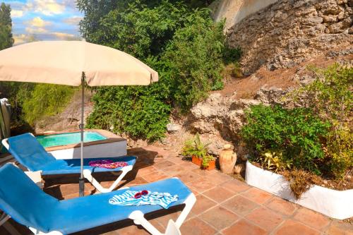two chairs and an umbrella on a patio at La Cuadra in Frigiliana