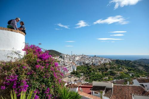 a man and a woman sitting on top of a building at La Cuadra in Frigiliana