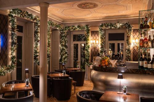 a restaurant with a bar with plants on the walls at Hotel Villa Flori in Como
