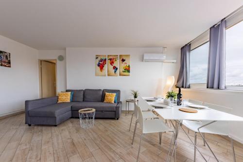 un salon avec un canapé et une table dans l'établissement Le Pierre Cazeneuve vue et climatisation, à Toulouse