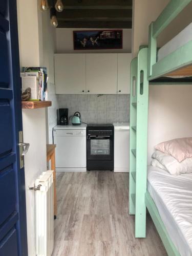 a small room with a bunk bed and a kitchen at Lau Anaiak in Bidart