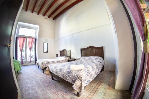 a bedroom with two beds and a window at La Fuente Catedral in Puebla