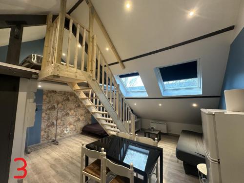 een loft met een trap en een tv in een kamer bij gites des cigognes in Duinkerke
