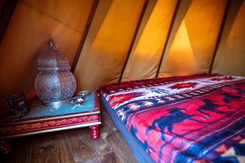 a corner of a room with a bed and a table at Agricampeggio Equinox in Carpignano Sesia