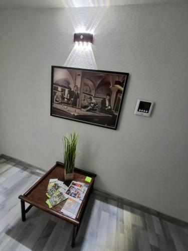 a living room with a table and a picture on the wall at GRooms in Gemmrigheim