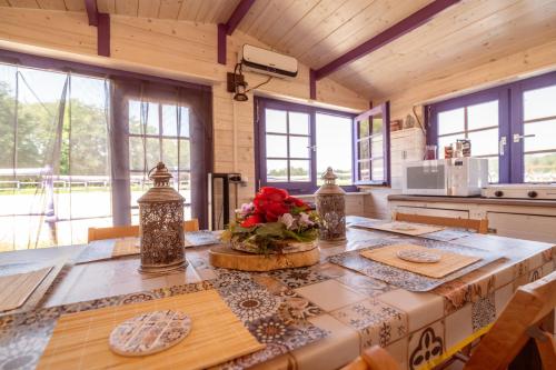 a kitchen with a large wooden table with flowers on it at Agricampeggio Equinox in Carpignano Sesia