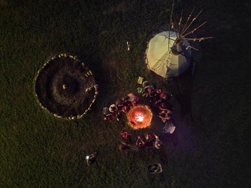 an overhead view of a group of people standing around a tent at Agricampeggio Equinox in Carpignano Sesia