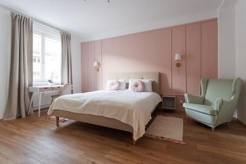 a bedroom with a bed and a green chair at Papageno Apartments in Vienna