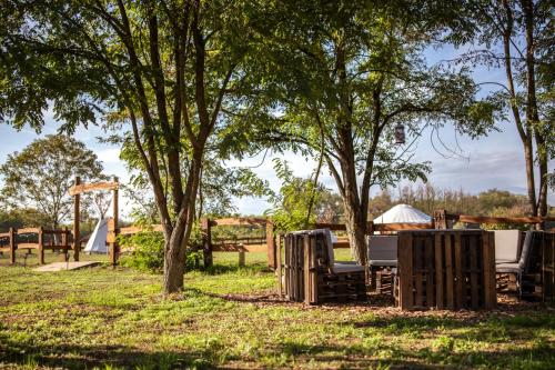 a picnic table and chairs under trees in a park at Agricampeggio Equinox in Carpignano Sesia